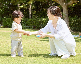 芝生で遊ぶ親子の写真